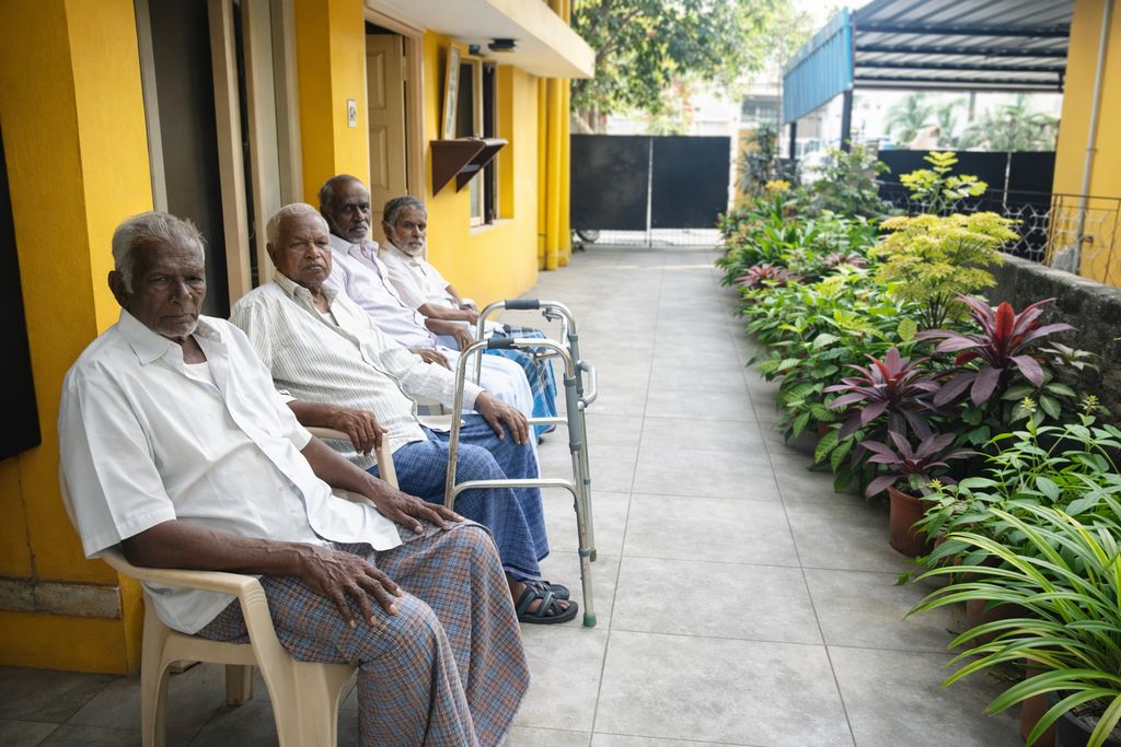 Elderly residents relaxing in the bright and airy common living room at John Bosco Care Home