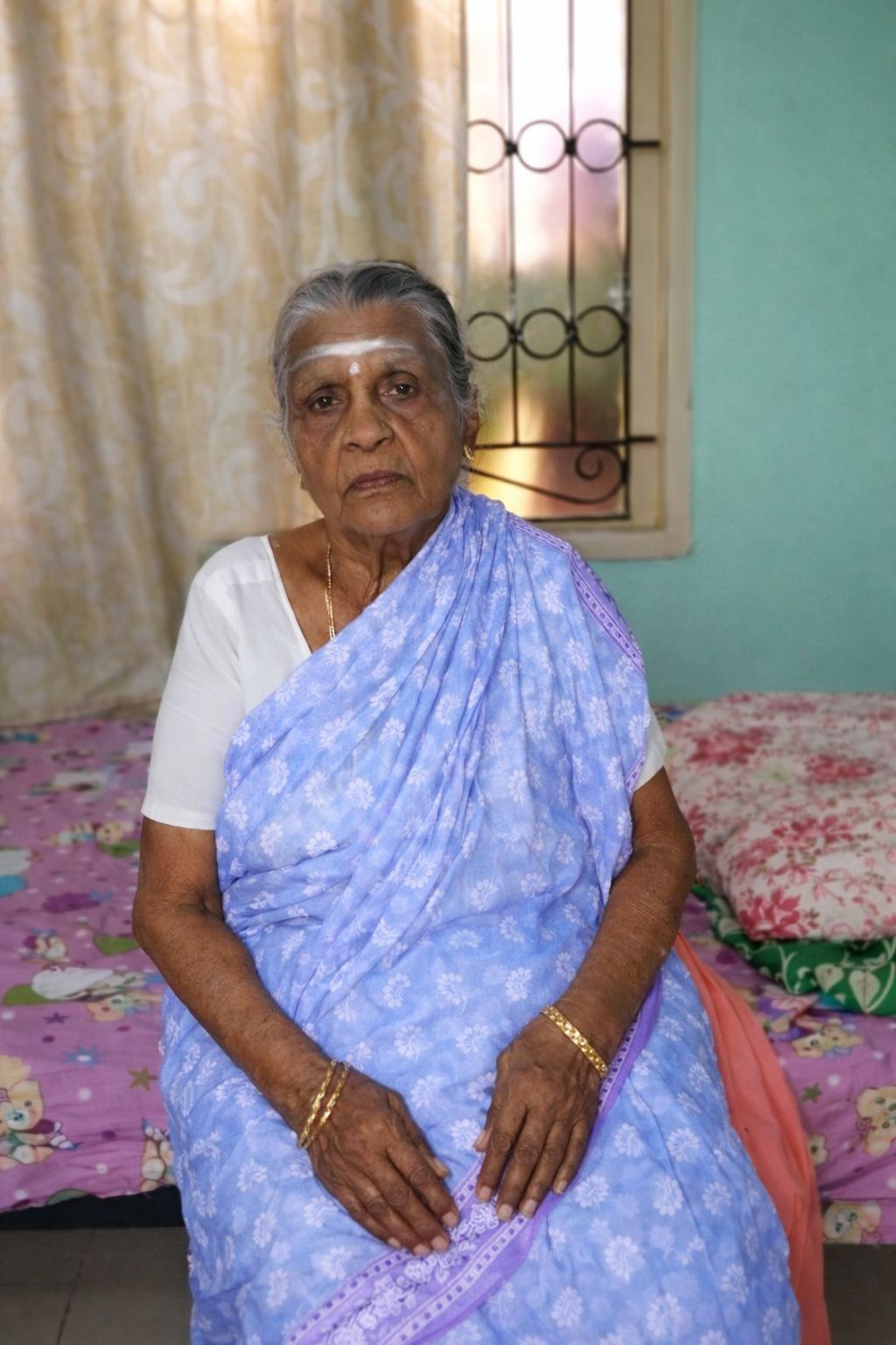 Smiling elderly woman resident wearing traditional saree at John Bosco Care Home